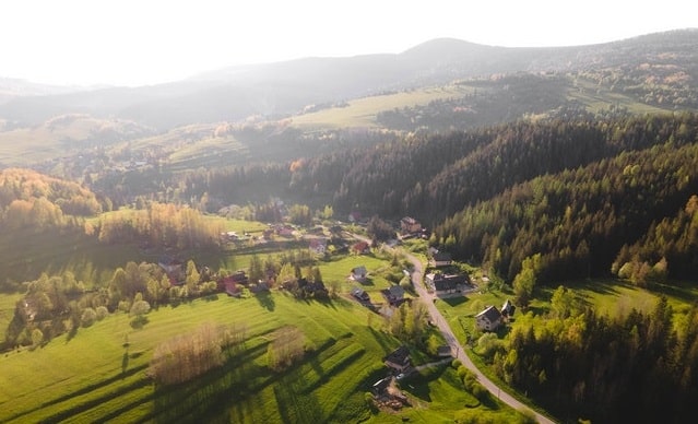 malá dedina a okolo zelené polia a lesy